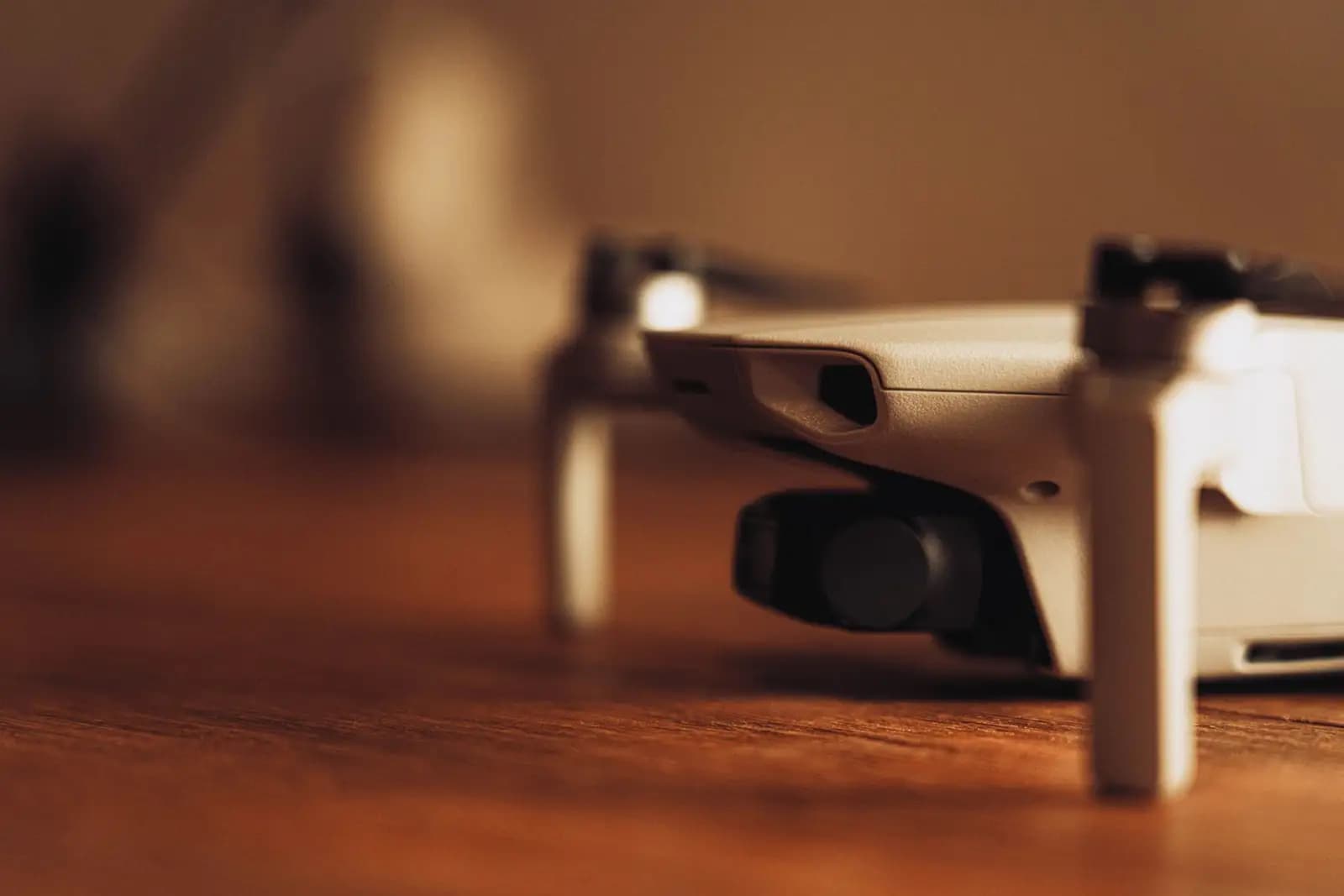 Drone kompak diletakkan di atas meja kayu dengan pencahayaan hangat ruang baca