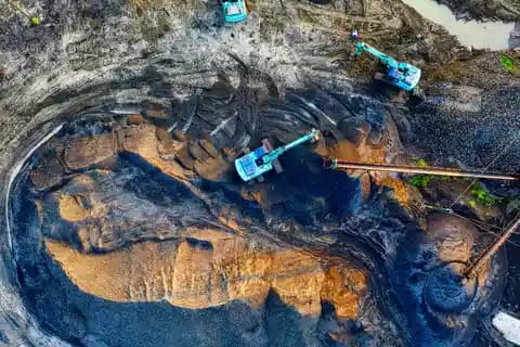 Drone industri terbang di atas tumpukan material stockpile pertambangan