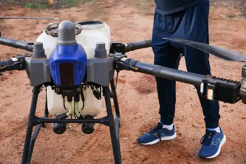 Pilot drone profesional sedang menerbangkan drone di area perkebunan Sumatera Utara