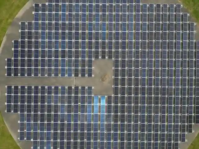 Drone terbang di atas ladang panel surya yang luas saat inspeksi