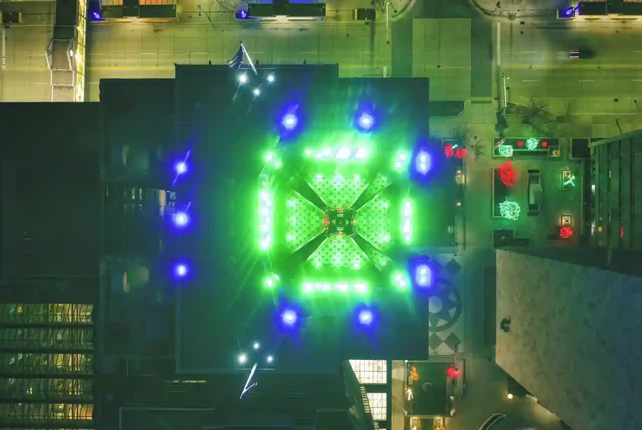 Drone swarm membentuk formasi di langit malam perkotaan