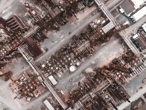 Drone keamanan terbang di atas kompleks industri saat matahari terbit