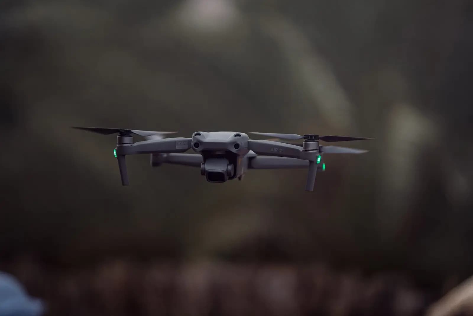Drone quadcopter melayang stabil di udara dengan latar belakang biru