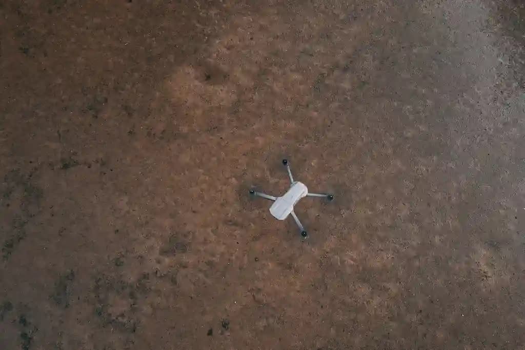 Drone terbang di atas area lahan luas yang sedang disurvei untuk agunan bank