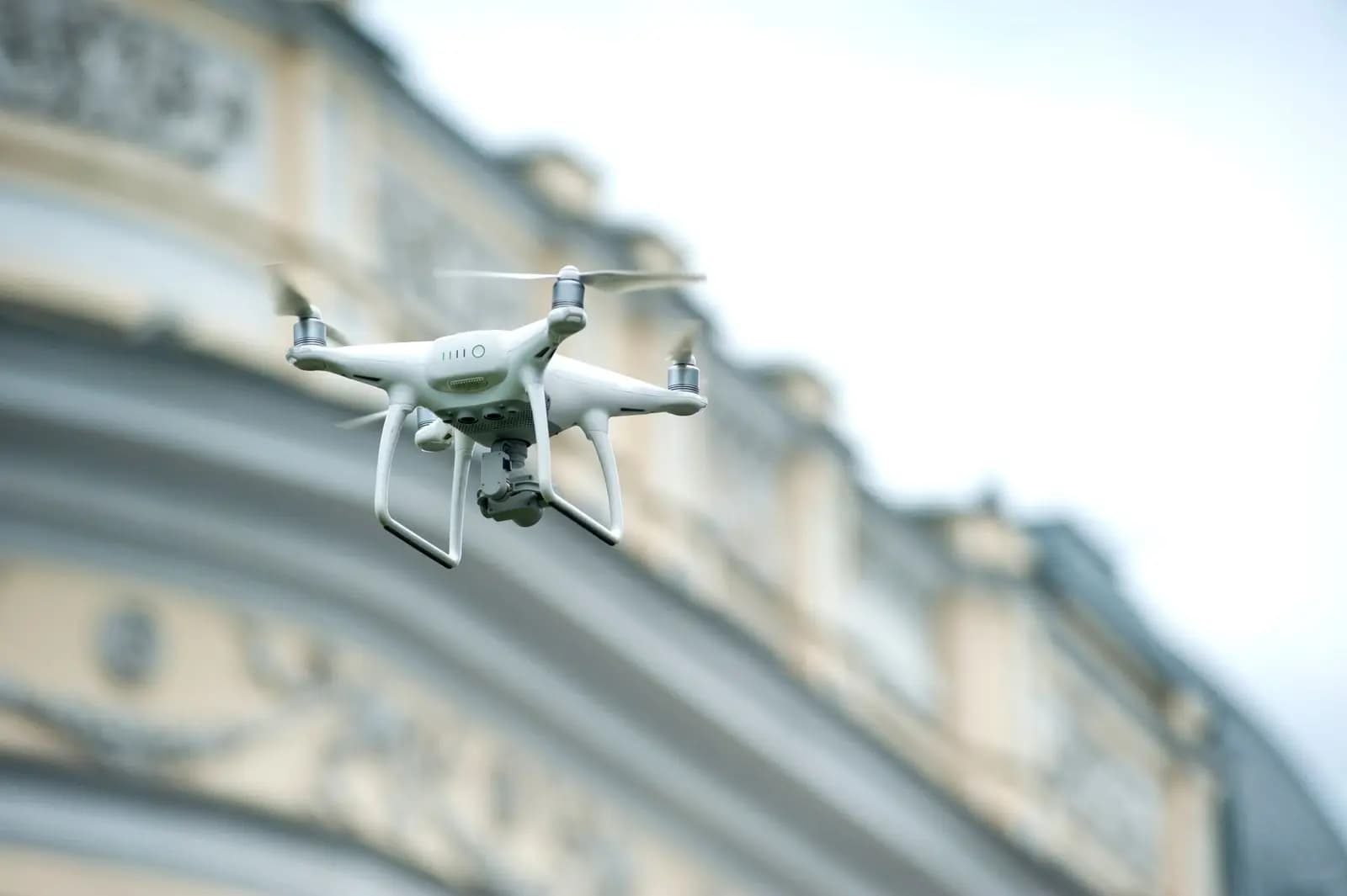 Drone terbang di atas kota dengan gedung-gedung tinggi di latar belakang
