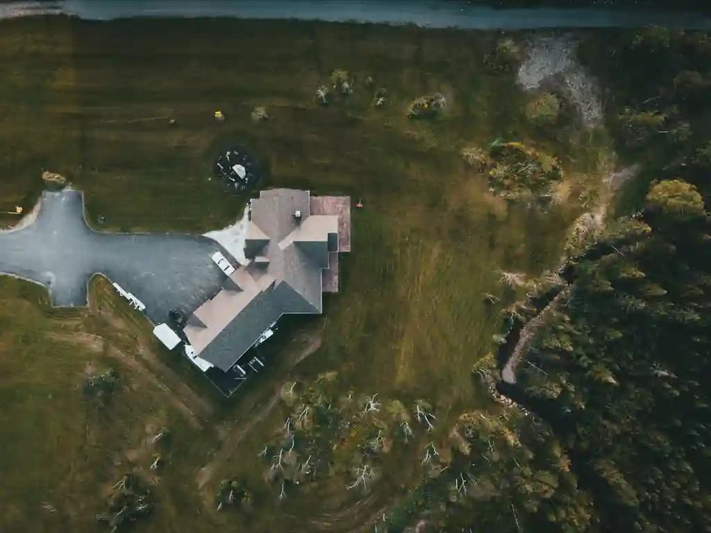 Pilot drone profesional mengoperasikan drone di atas kawasan perumahan modern