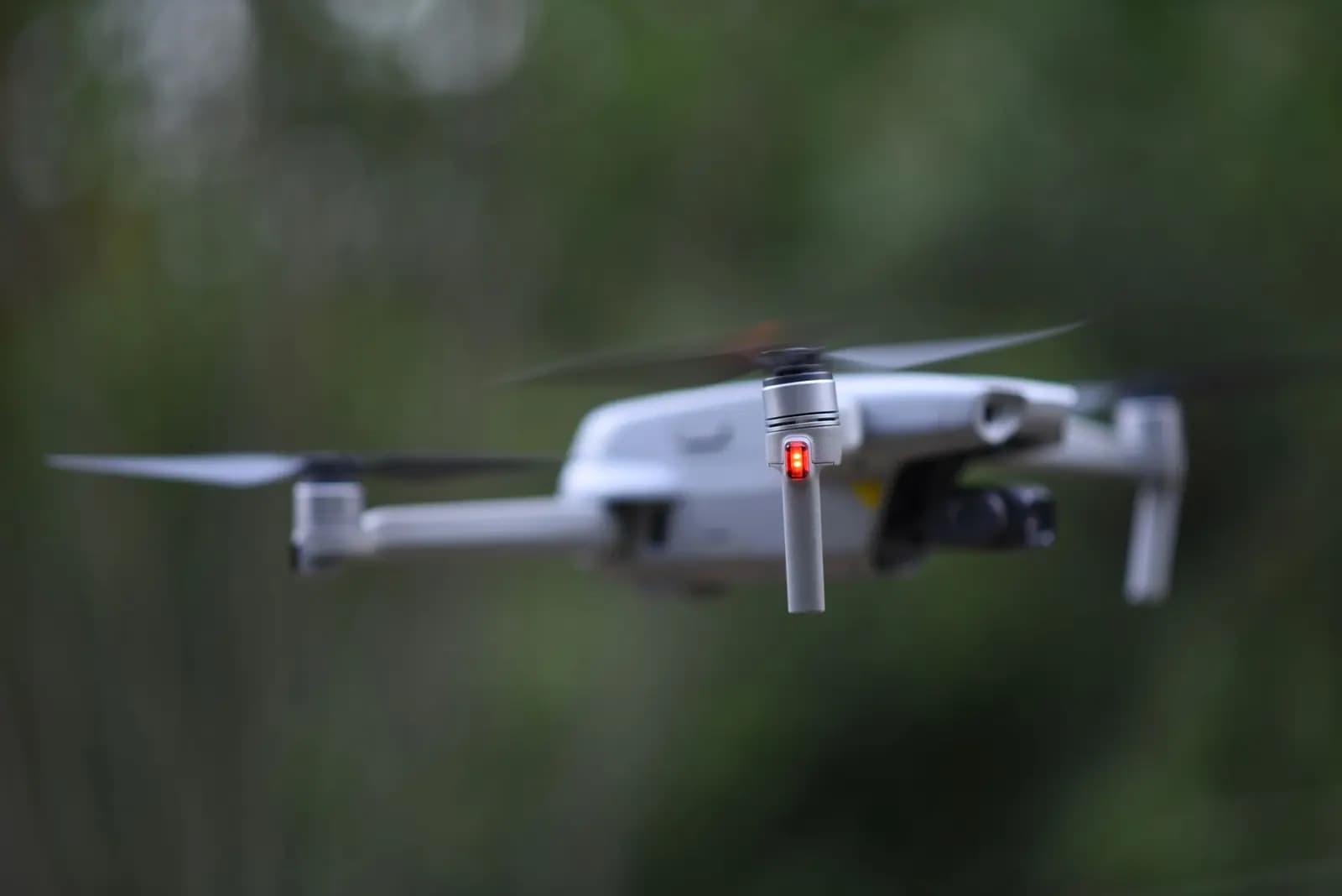Drone industri terbang stabil di dalam ruangan gelap dengan lampu LED bawah menyala