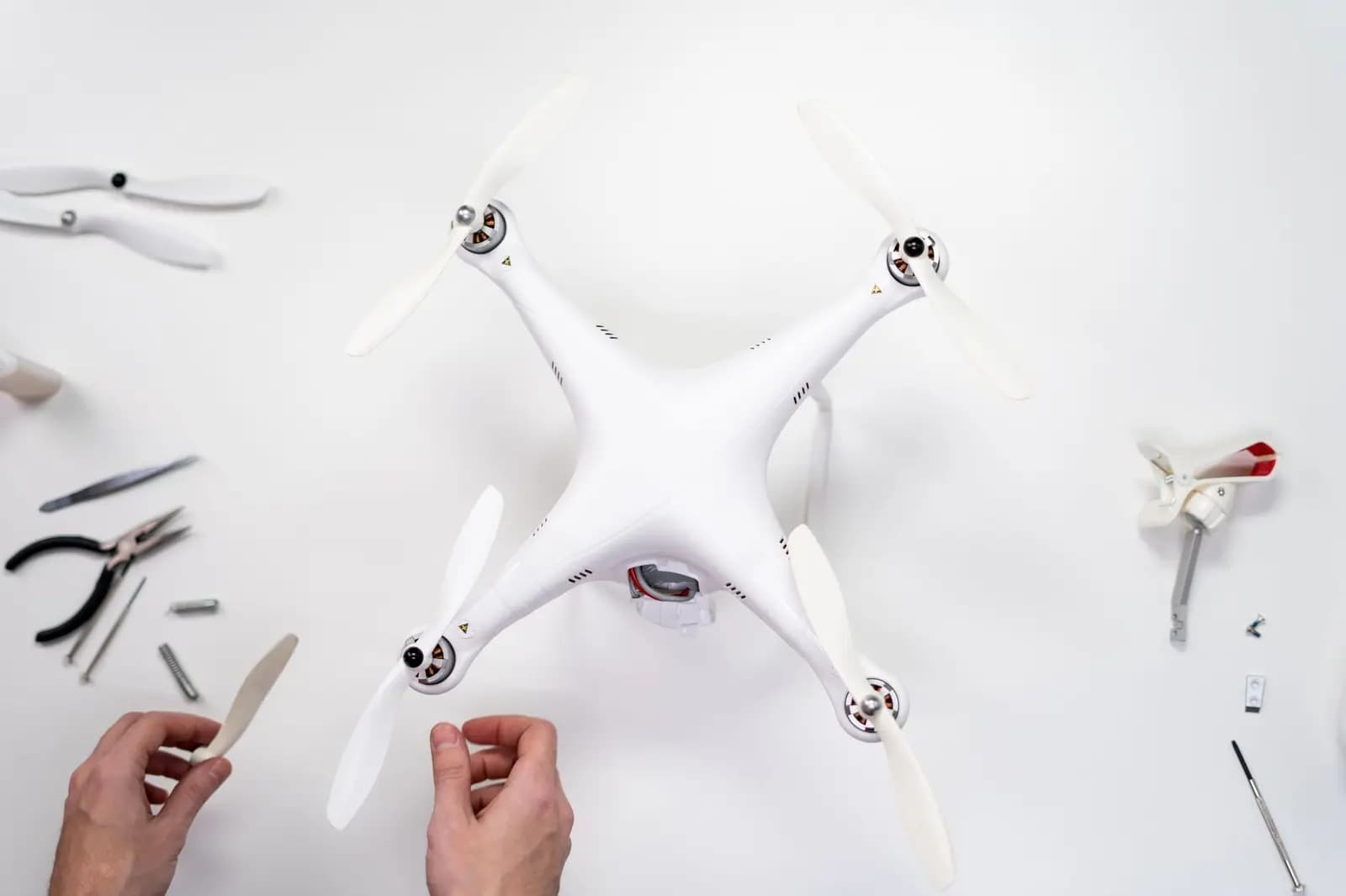 Seorang remote pilot memegang sertifikat RPC di samping drone