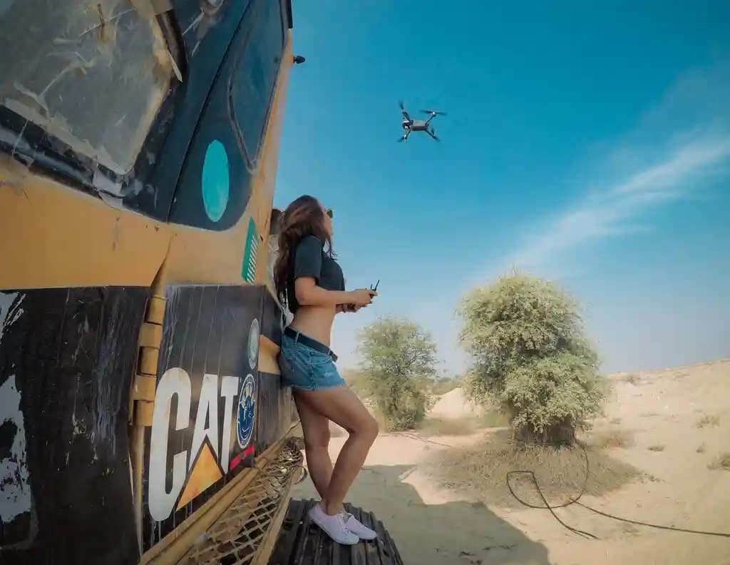 Pilot drone bersertifikat sedang mengoperasikan drone di lokasi konstruksi.