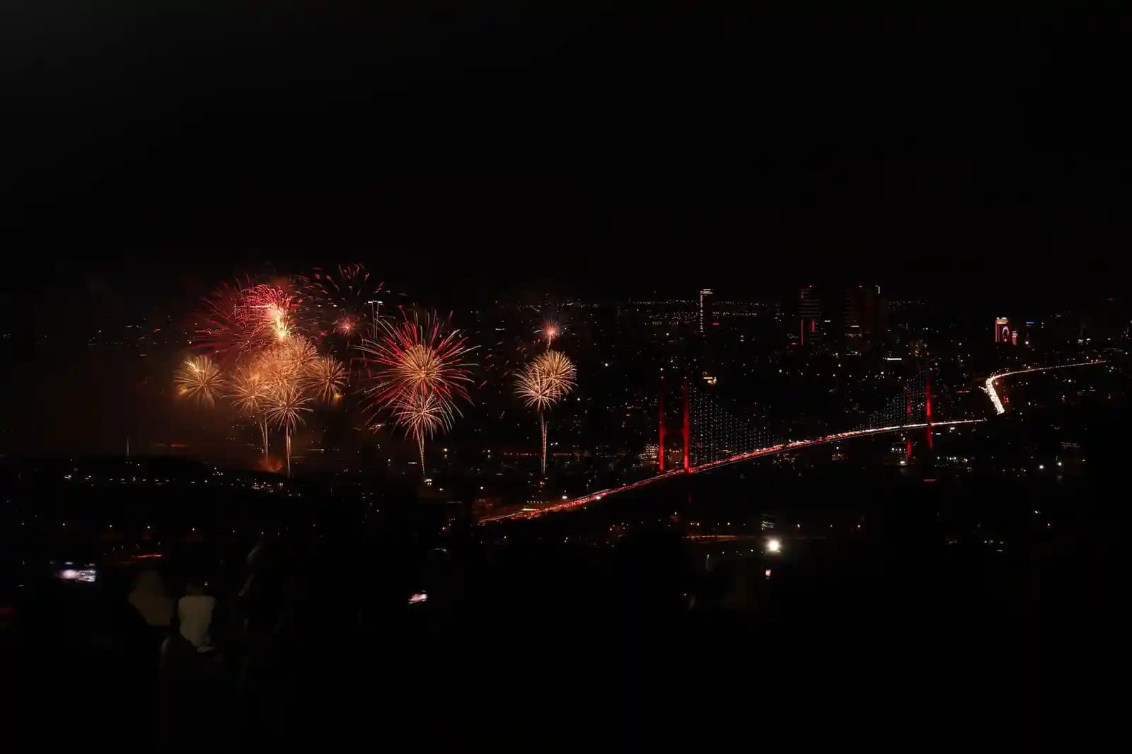 Drone light show di atas kota saat malam hari dengan pilot mengawasi