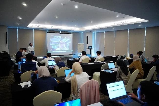 Kelas teori pelatihan remote pilot dengan peserta menyimak materi di depan layar presentasi